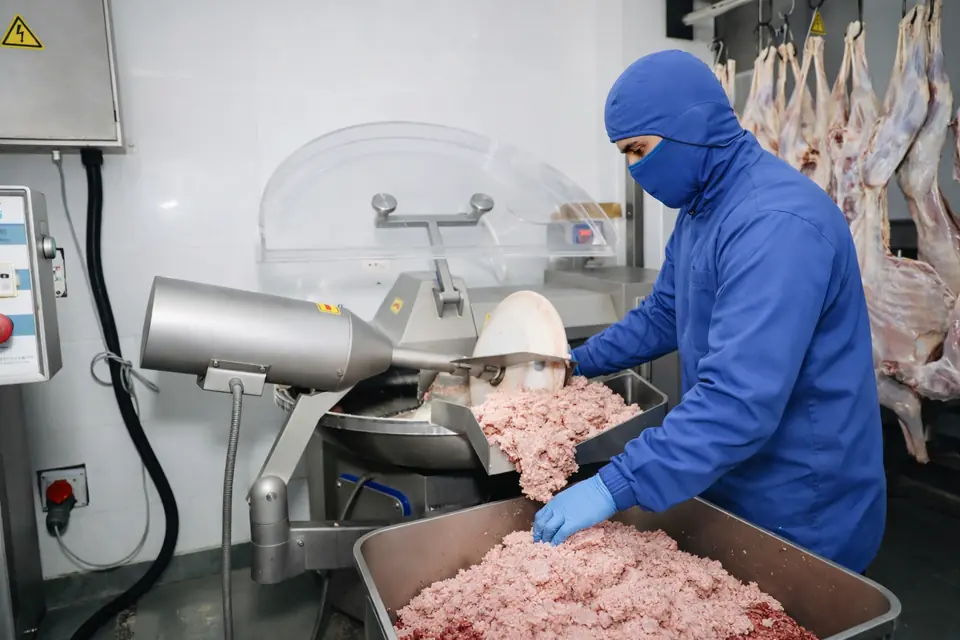 Fine mince coming out of a bowl cutter