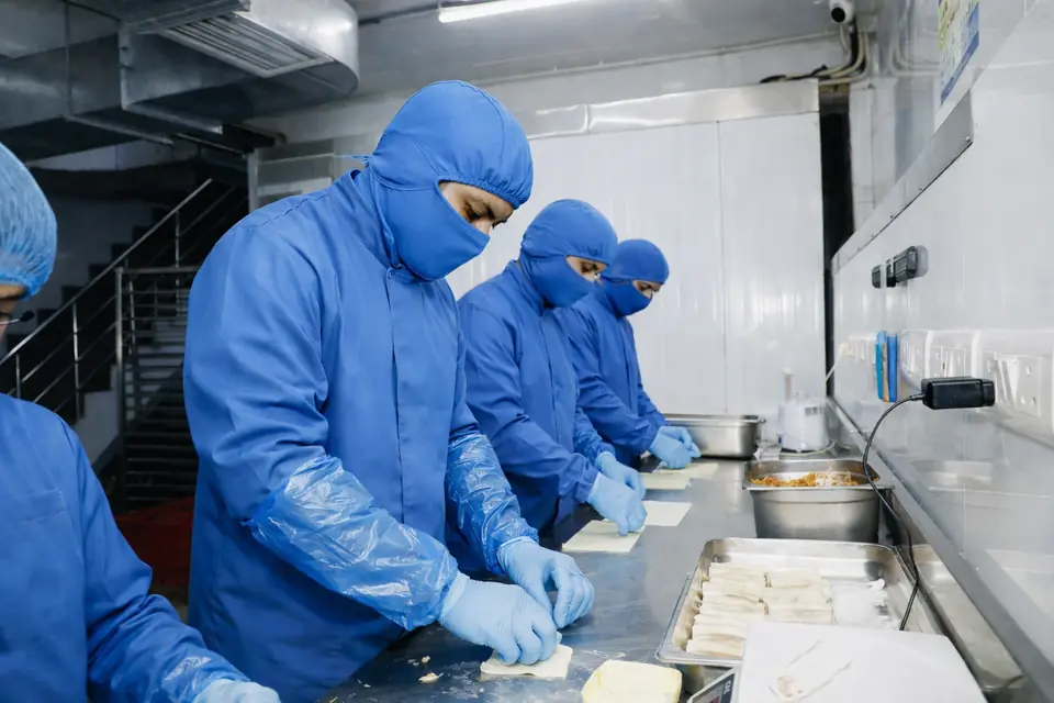 Workers hand-rolling spring rolls